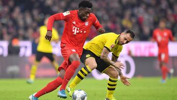 MUNICH, GERMANY - NOVEMBER 09: Alphonso Davies of FC Bayern Munich runs with the ball under pressure from Paco Alcacer of Borussia Dortmund during the Bundesliga match between FC Bayern Muenchen and Borussia Dortmund at Allianz Arena on November 09, 2019