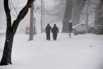 Una pareja se abre paso entre la nieve para asistir al desfile anual de vacaciones de Hamburgo el 30 de noviembre de 2024 en Hamburgo, Nueva York.