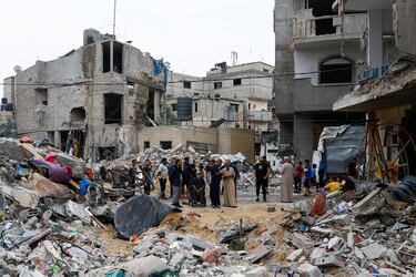 Personas palestinas inspeccionan los edificios destruidos por los ataques israeles en Rafah.