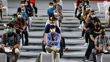 People wearing protective masks sit as they queue for their turn to receive a dose of the AstraZeneca coronavirus disease (COVID-19) vaccine at the Istora Senayan Stadium in Jakarta, Indonesia, June 16, 2021. REUTERS/Ajeng Dinar Ulfiana