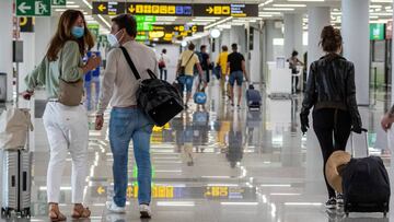 GRAF4447. PALMA DE MALLORCA, 21/06/2020.- Viajeros ataviados con mascarillas a su llegada al Aeropuerto de Palma de Mallorca, este domingo, durante el primer d&iacute;a del fin del estado de alarma, en el que se espera la llegada de 25 vuelos internaciona