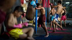 Varios chavales entrenan en una academia de Muay Thai en Bangkok.