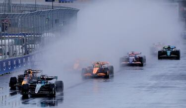 La lluvia, protagonista en la salida. En la imagen, George Russell y  Max Verstappen, en cabeza de carrera, dejan una estela de agua sobre el asfalto mojado.