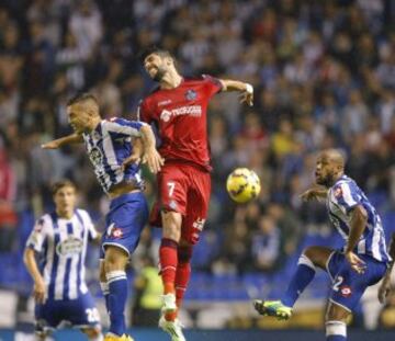 El centrocampista del Getafe Ángel Lafita salta a por un balón con el centrocampista argentino del Deportivo Luis Fariña, ante su compañero, el defensa brasileño Sidnei Rechel da Silva.