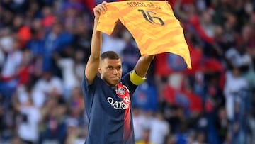 Paris Saint-Germain's French forward Kylian Mbappe celebrates scoring his team's second goal with holding up jersey of Paris Saint-Germain's Spanish goalkeeper Sergio Rico, who is in serious condition after a horse-riding accident, during the French L1 football match between Paris Saint-Germain (PSG) and Clermont Foot 63 at the Parc des Princes Stadium in Paris on June 3, 2023. (Photo by FRANCK FIFE / AFP)