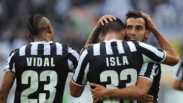 TURIN, ITALY - OCTOBER 27: Carlos Tevez (R) of Juventus celebrates with team-mates Mauricio Isla and Arturo Vidal after scoring their team's second goal during the Serie A match between Juventus and Genoa CFC at Juventus Arena on October 27, 2013 in Turin, Italy. (Photo by Valerio Pennicino/Getty Images)
