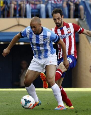 El defensa del Atlético de Madrid Juanfran disputa el balón con el centrocampista marroquí del Málaga Nordin Amrabat.