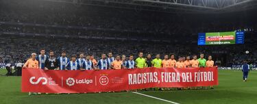 Jugadores del Espanyol y del Atlético, junto al equipo arbitral, portan la pancarta contra el racismo; 'Racistas, fuera del fútbol'.