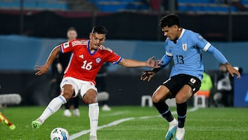 Chile's Nayel Mehssatou, left, and Uruguay's Maximiliano Araujo battle for the ball during a qualifying soccer match for the FIFA World Cup 2026 at Centenario stadium in Montevideo, Uruguay, Friday Sept. 8, 2023.(AP Photo/Santiago Mazzarovich)