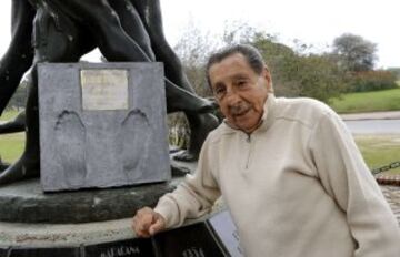 Ghiggia con la estatua en su honor que tiene en Montevideo.
