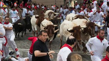 Participants run next to Cebada Gago fighting bulls on the second bullrun of the San Fermin festival in Pamplona, northern Spain on July 8, 2019. - On each day of the festival six bulls are released at 8:00 a.m. (0600 GMT) to run from their corral through the narrow, cobbled streets of the old town over an 850-meter (yard) course. Ahead of them are the runners, who try to stay close to the bulls without falling over or being gored. (Photo by JAIME REINA / AFP)