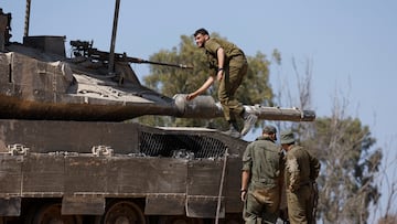 Israeli soldiers stand next to a tank, near the Israel-Gaza border, amid the ongoing conflict between Israel and the Palestinian Islamist group Hamas, in Israel, April 15, 2024. REUTERS/Amir Cohen