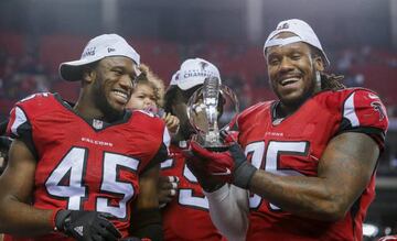 Atlanta Falcons linebacker Deion Jones (L) and Atlanta Falcons defensive tackle Jonathan Babineaux (R) hold the NFC Championship Trophy after the Falcons defeated the Green Bay Packers
