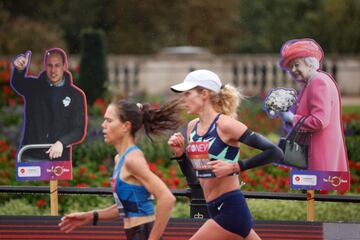 Dos corredoras pasan ante imágenes del príncipe Guillermo y la reina Isabel II de Gran Bretaña durante la carrera
femenina del Maratón de Londres 2020, en el centro de la ciudad. La edición de este año se disputa en un
circuito cerrado, en St Jamess Park, debido a las restricciones por la pandemia del coronavirus.