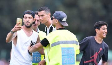 Juventus' Cristiano Ronaldo with a pitch invader at Villar Perosa.