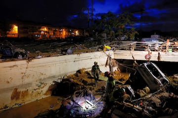 Equipos de rescate siguen buscando posibles víctimas al caer la noche tras las lluvias torrenciales que provocaron inundaciones en Alfafar, Valencia.