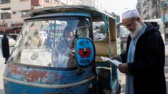 Men read newspapers, after the Pakistani foreign ministry said the country conducted strikes targeting separatist militants inside Iran, along a road in Karachi, Pakistan January 18, 2024. REUTERS/Akhtar Soomro