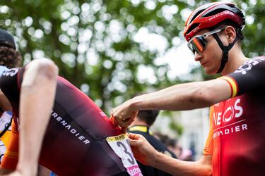 Carlos Rodríguez colocando el dorsal a su compañero de equipo en el Ineos, el ciclista belga Laurens de Plus.