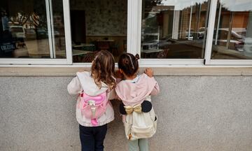 Dos niñas observan el interior vacío del colegio CEIP Amparo Alabau, en Alaquàs, Valencia.