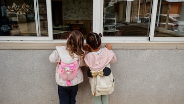 Dos niñas observan el interior vacío del colegio CEIP Amparo Alabau, en Alaquàs, Valencia.