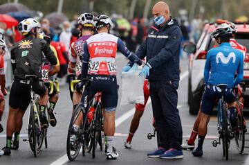 Un miembro del personal recoge la mascarilla del piloto francés del Team Trek, Julien Bernard, antes del inicio de la novena etapa de la carrera ciclista Giro de Italia 2020, una ruta de 207 kilómetros entre San Salvo y Roccaraso, 