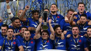 TOPSHOT - France&#039;s players celebrate with the trophy after winning the Six Nations rugby union tournament following a win in the match between France and England at the Stade de France in Saint-Denis, outside Paris, on March 19, 2022. (Photo by FRANCK FIFE / AFP)