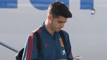 &Aacute;lvaro Morata mira el m&oacute;vil mientras desembarca de un avi&oacute;n.