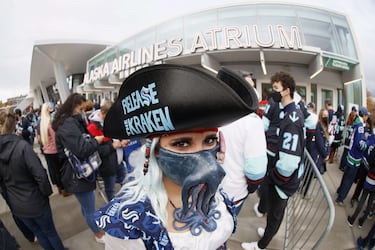 Una aficionada espera en la fila para entrar al partido inaugural de la liga americana de hockey sobre hielo (NHL) ataviada con un gorro pirata y un calamar gigante, distintivo de los Seattle Kraken. Pese a su entrega, no pudo celebrar la victoria de su equipo, pues ganaron los visitantes, los Vancouver Canucks (2-4).
