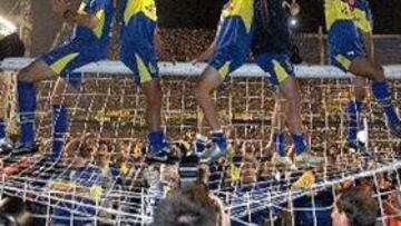 <b> EUFÓRICOS. </b> Los jugadores de Boca celebran el título encaramados a lo alto de una de las porterías.