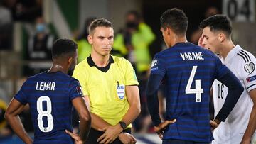 Swiss referee Sandro Scharer (C) argues with France's midfielder Thomas Lemar (L) and France's defender Raphael Varane prior to validate France's forward Antoine Griezmann's goal during the FIFA World Cup Qatar 2022 qualification Group D football match between France and Bosnia-Herzegovina, at the Meineau stadium in Strasbourg, eastern France, on September 1, 2021. (Photo by FRANCK FIFE / AFP)