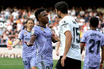 Real Madrid's Brazilian forward Vinicius Junior (L) talks to Valencia's Turkish defender Cenk Ozkacar 