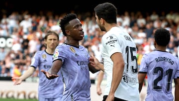 Real Madrid's Brazilian forward Vinicius Junior (L) talks to Valencia's Turkish defender Cenk Ozkacar as he reacts to being insulted from the stands during the Spanish league football match between Valencia CF and Real Madrid CF at the Mestalla stadium in Valencia on May 21, 2023. (Photo by JOSE JORDAN / AFP)