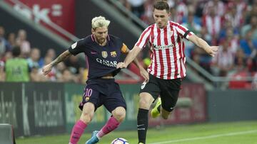 Leo Messi lucha por un balón con Aymeric Laporte durante el partido de Liga Santander entre Athletic de Bilbao y F.C. Barcelona.