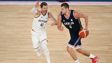 Serbia's #15 Nikola Jokic (R) drives the ball past Germany's #42 Andreas Obst in the men's Bronze Medal basketball match between Germany and Serbia during the Paris 2024 Olympic Games at the Bercy Arena in Paris on August 10, 2024. (Photo by Paul ELLIS / AFP)