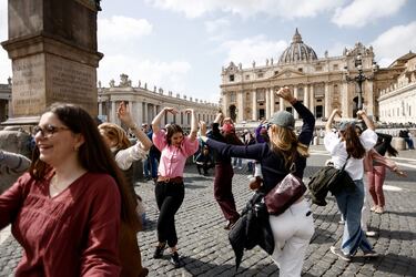 La gente reacciona ante la primera aparición pública del Papa Francisco en cinco semanas, el día de su alta del Hospital Gemelli, mientras la ven en una pantalla gigante en la Plaza de San Pedro, en el Vaticano.