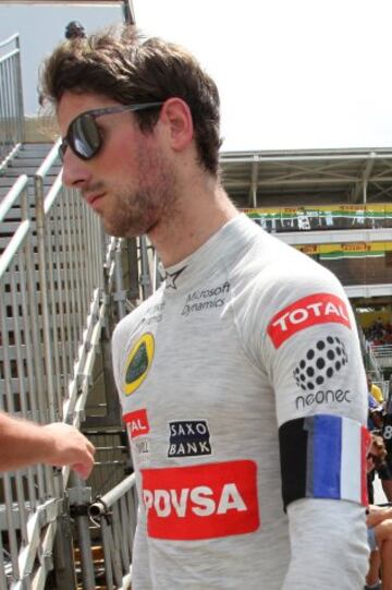 Romain Grosjean, de la escudería Lotus, posta una bandera de Francia en su brazo, en homenaje a las víctimas de los atentados.