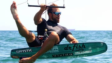 Alejandro Climent sentado sobre su foil de Formula Kite con las gafas de sol puestas. 