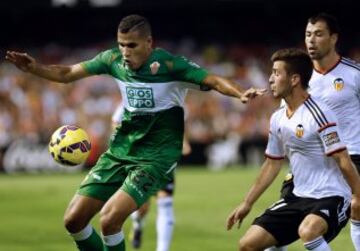 El delantero brasileño del Elche, Jonathas (i), intenta controlar el balón ante los jugadores del Valencia, José Luis Gayá (2d) y Javi Fuego, durante el encuentro correspondiente a la novena jornada de primera división, que disputan esta noche en el estadio de Mestalla. 