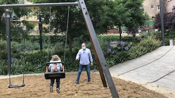 Una ni&ntilde;a y su abuelo juegan en los columpios