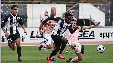 Carlos Blanco despeja un balón ante la presencia de Koroma. Por detrás corren Javier Añón y Masllorens.
