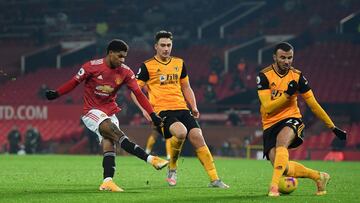 MANCHESTER, ENGLAND - DECEMBER 29: Marcus Rashford of Manchester United shoots past Romain Saiss of Wolverhampton Wanderers during the Premier League match between Manchester United and Wolverhampton Wanderers at Old Trafford on December 29, 2020 in Manch