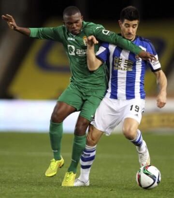 El defensa de la Real Sociedad, Yuri Berchiche (d), disputa un balón con el centrocampista camerunés del Oviedo, Emmanuel Franck Omgba, durante el partido de vuelta de dieciseisavos de final de la Copa del Rey, que disputan esta noche en el estadio de Anoeta de San Sebastián.