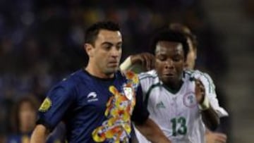 El centrocampista de la selecci&oacute;n catalana de f&uacute;tbol Xavi Hern&aacute;ndez (i) disputa el bal&oacute;n con el jugador de la selecci&oacute;n nigeriana Emmanuel Emenike (d) en el partido amistoso que ambos equipos disputan hoy en el estadio de Cornella-Prat, en Barcelona. 