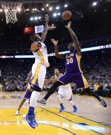 Julius Randle lucha por el balón con Festus Ezeli, de los Golden State Warriors.