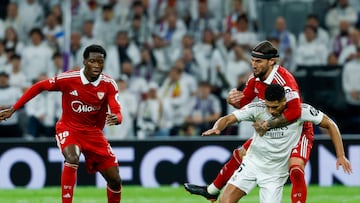 MADRID, 20/12/2025.- El centrocampista inglés del Real Madrid, Jude Bellingham, cae ante el defensa serbio del Sevilla, Nemanja Gudelj, durante el encuentro de la jornada 17 de LaLiga entre Real Madrid y Sevilla FC celebrado este sábado en el estadio Santiago Bernabéu, en Madrid. EFE / Javier Lizón.