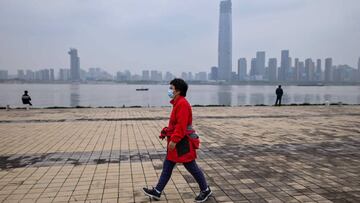 Una mujer con mascarilla camina en Wuhan (China).