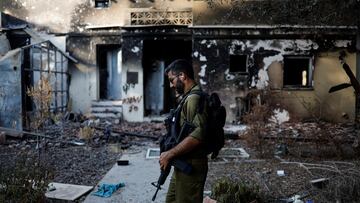 An Israeli soldier walks past a house that was damaged following a deadly attack by Hamas gunmen from the Gaza Strip, in Kibbutz Beeri, southern Israel, October 25, 2023. REUTERS/Ammar Awad