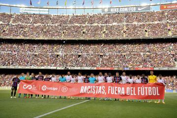 Jugadores del Barcelona y del Mallorca, junto al equipo arbitral, portan la pancarta contra el racismo; 'Racistas, fuera del fútbol'.