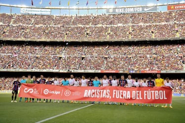 Jugadores del Barcelona y del Mallorca, junto al equipo arbitral, portan la pancarta contra el racismo; 'Racistas, fuera del fútbol'.