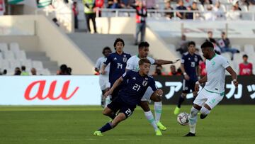 Japan's midfielder Ritsu Doan (C) is marked by Saudi Arabia's defender Ali Al-Bulaihi (R) during the 2019 AFC Asian Cup Round of 16 football match between Japan and Saudi Arabia at the Sharjah Football Stadium in Sharjah on January 21, 2019. (Ph